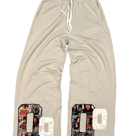 Light beige drawstring sweatpants with graphic patches.