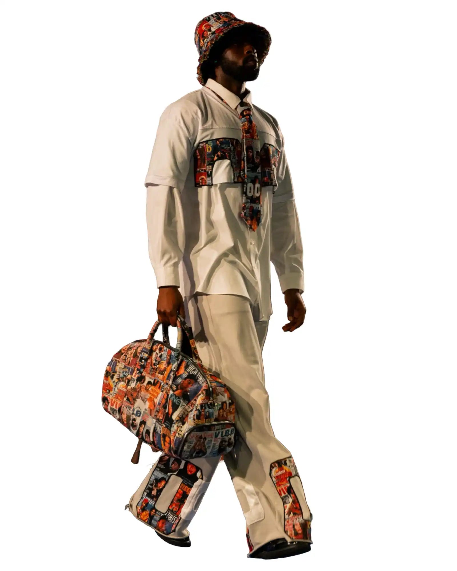 A person in a white shirt and pants with a colorful pattern, holding a matching duffel bag.