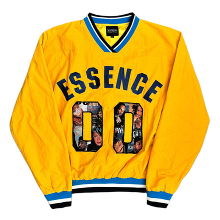 Bright yellow varsity-style jacket with ’essence’ in navy blue arched lettering above a collage-patterned “00” on the chest, accented by bold blue and black trim.