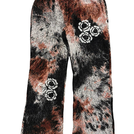 Tie-dye sweatpants with floral embroidery in white on a black, red and gray background.